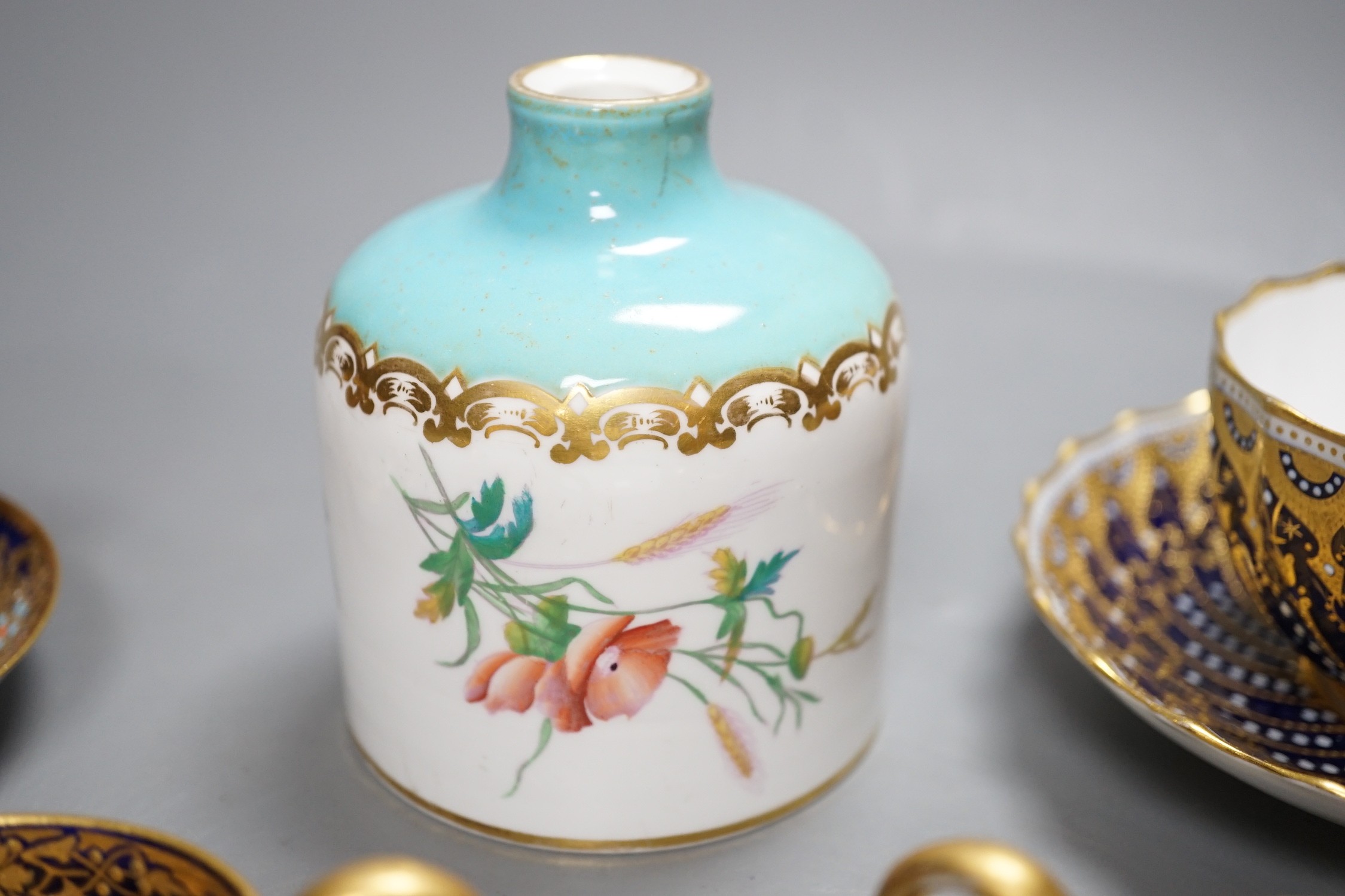 A 19th century Coalport fan shaped dish painted with a Loch scene, two small cup with twin handles decorated with raised gilding on a cobalt blue ground with crown marks, a Copeland jewelled cup and saucer with blue grou